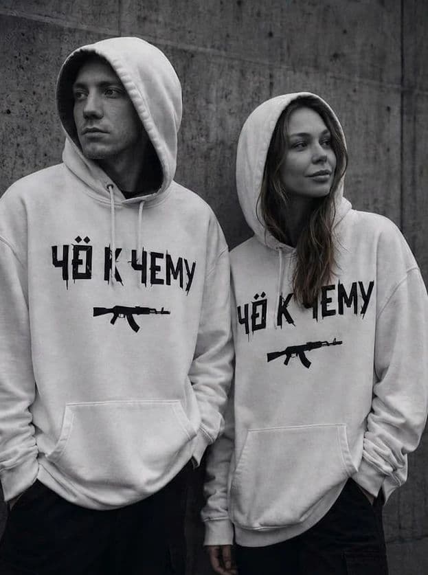 Двое в белых худи с принтом "Чё к чему" у бетонной стены, по пояс, чёрно-белый кадр
